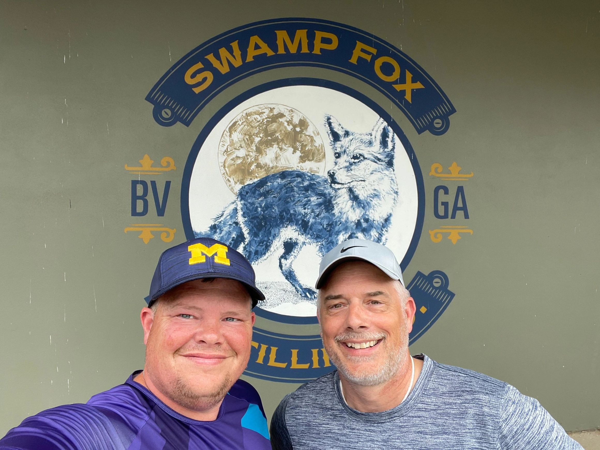 Two riders in front of the Swamp Fox Distillery mural